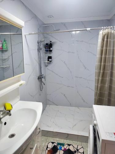 a white bathroom with a shower and a sink at Эко Жайлоо in Kaji-Say