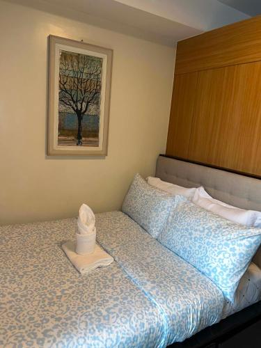 a bedroom with a bed with a picture on the wall at Shell Residences in Sampong