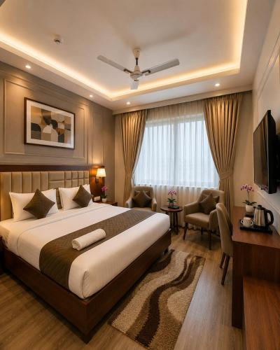a bedroom with a bed and a desk and a television at Hotel Lotus Palace in Lucknow