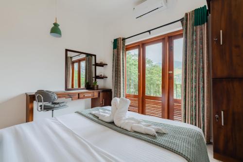 a bedroom with a white bed with a window at Boutique Dinu in Kandy