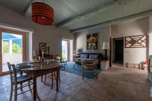 a living room with a table and chairs and a couch at La Terrazza di Rivoria - Vue magique & Terrasse in Masera