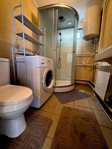 a bathroom with a washing machine and a toilet at Sun Garden Guest House in Ak-Say