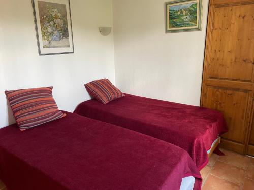 two beds in a room with purple sheets at location verdon in Les Salles-sur-Verdon