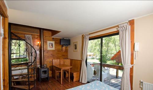 ein Schlafzimmer mit Bett und Schreibtisch und ein Balkon in der Unterkunft Añañucas III in Las Trancas
