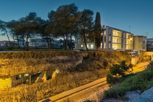 a building in a city with a yard with trees at MARIMAR - Apartments OTRANTO in Otranto