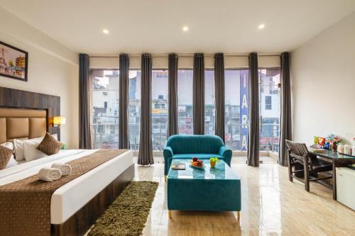 a bedroom with a bed and a chair and a desk at Hotel Apple Tree - Near Mahipalpur Market in New Delhi