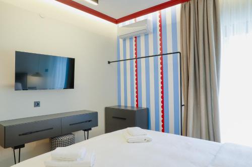a room with a bed and a desk and a television at Olympia 3 in Xanthi