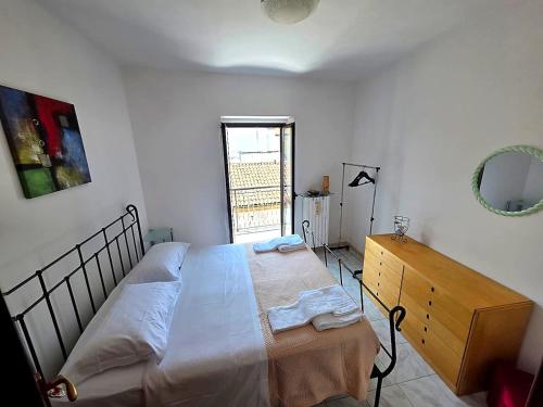 a bedroom with a bed and a dresser and a window at Casa Cordara Apartment in Nizza Monferrato