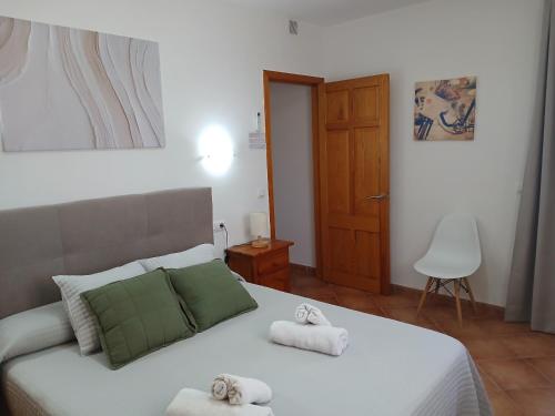 a bedroom with a white bed with towels on it at Villa Moll in Cala Morell