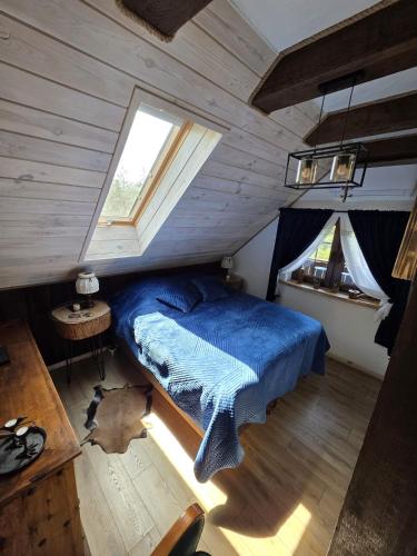 a bedroom with a blue bed and a window at Woodland Apartment Small in Berezka