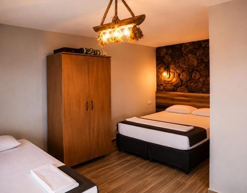 a bedroom with two beds and a cabinet and a chandelier at Assos Plus in Ayvacık