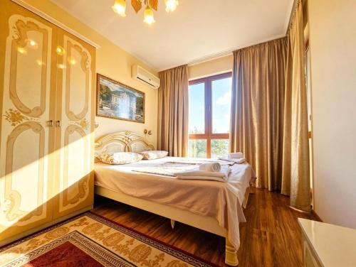a bedroom with a bed and a large window at Europroperties Golden Line in Golden Sands