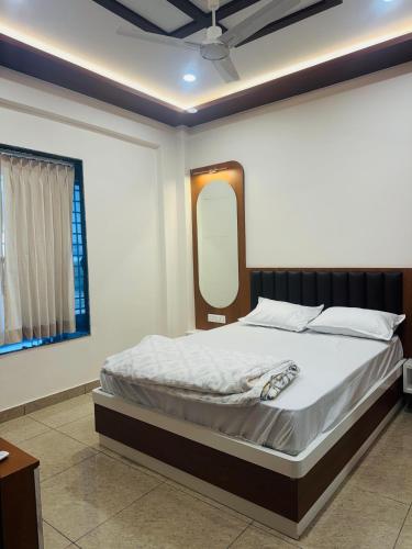 a bedroom with a large bed with a mirror at Rudraksh Hotel & Resturant in Lordi