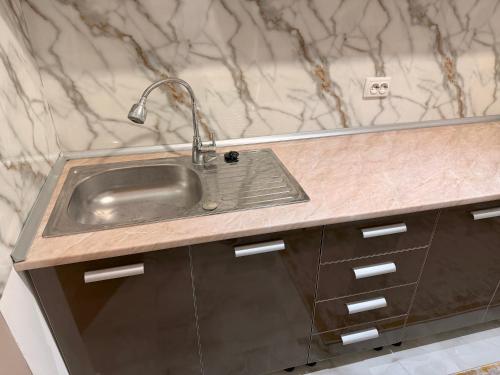 a kitchen sink with a faucet on top of it at Dragasani Cozy Apartament in Drăgăşani