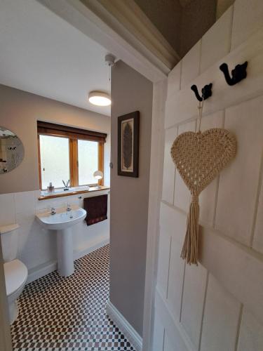 a bathroom with a heart on the wall and a sink at The Hen Den in Ludlow