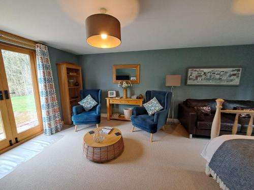 a bedroom with a bed and chairs and a table at The Hen Den in Ludlow