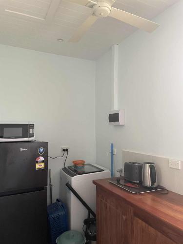 a kitchen with a refrigerator and a counter with a microwave at Helt Vanua Lodge in Saraotou