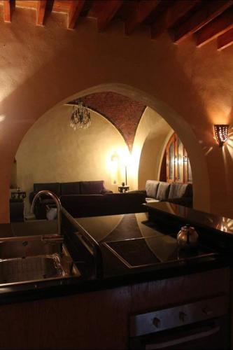 a kitchen with a sink and a living room with a couch at Kom El Dikka Agri Lodge in ‘Izbat an Nāmūs