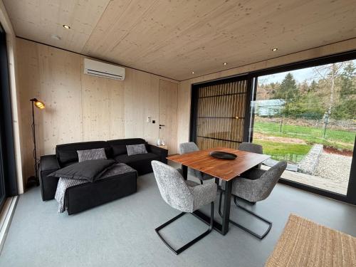 a living room with a table and a couch at Chalet WaldZeit in Weiskirchen
