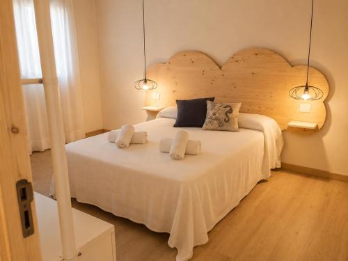 a bedroom with a large white bed with two pillows at Apartamentos Es Cupina in La Mola