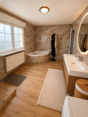a bathroom with a tub and a sink at 185 m duplex with pool near Strasbourg in Ittenheim