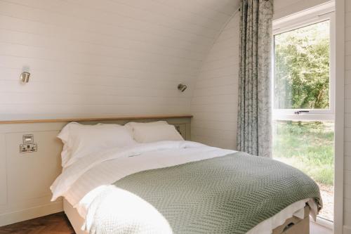 ein Bett in einem Zimmer mit Fenster in der Unterkunft Liba Vineyard in Porton