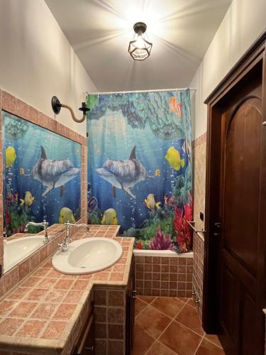 a bathroom with a sink and a fish shower curtain at Villa Valle Tassignana in Casperia