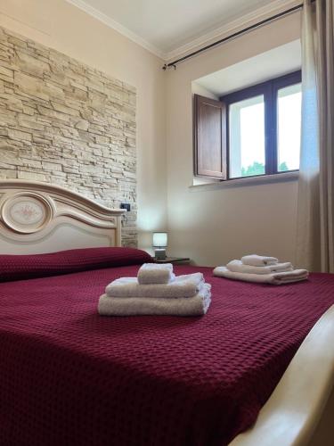 a bedroom with a red bed with towels on it at Villa Valle Tassignana in Casperia