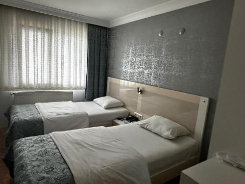 a hotel room with two beds and a window at Samsun Park Hotel in Samsun