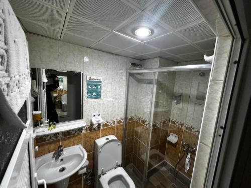 a bathroom with a toilet and a sink and a mirror at Samsun Park Hotel in Samsun