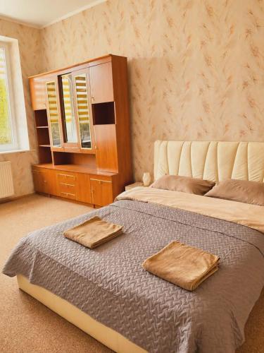 a bedroom with a bed with two towels on it at Svečių namai miestelio centre in Mosėdis