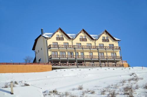 a large building on top of a snow covered hill at Penzion Na Vršku in Branná