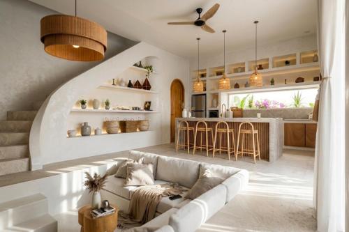 a living room with a couch and a kitchen at Svara Boutique Residences in Uluwatu