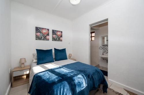 a bedroom with a bed with blue and white sheets at St Rand Holiday House in Strand