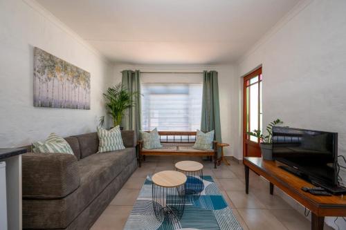 a living room with a couch and a tv at St Rand Holiday House in Strand
