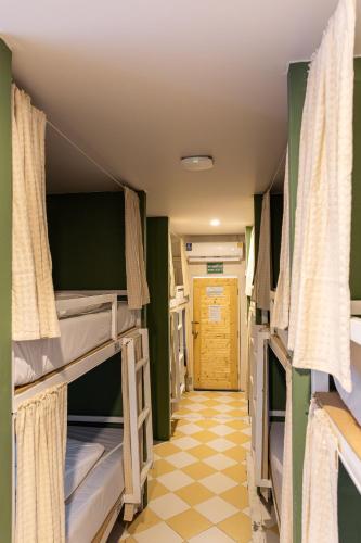 a room with three bunk beds and a hallway at Haonorn Hostel in Thong Sala