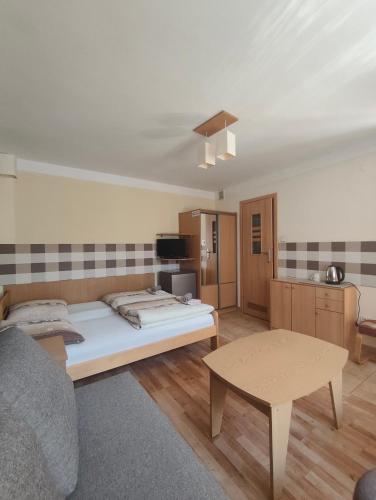 a living room with a bed and a table at Noclegi Pod Lipami in Zwierzyniec