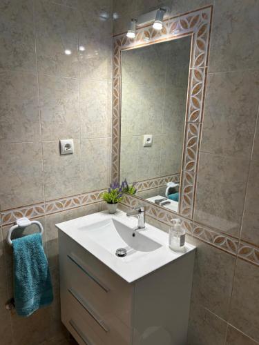 a bathroom with a sink and a large mirror at Los Flamencos Villa in Los Alcázares