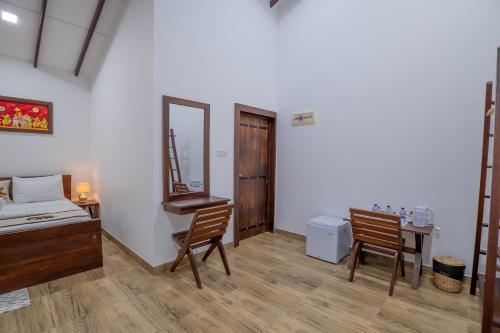 a bedroom with a bed and a desk and a mirror at Into The Wild Sigiriya in Sigiriya