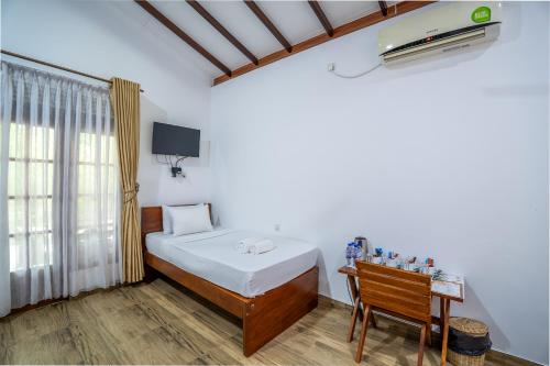 a bedroom with a bed and a desk and a window at Into The Wild Sigiriya in Sigiriya