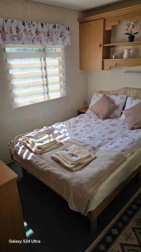 a bedroom with a bed with towels on it at Mazurski Zakątek in Ławki