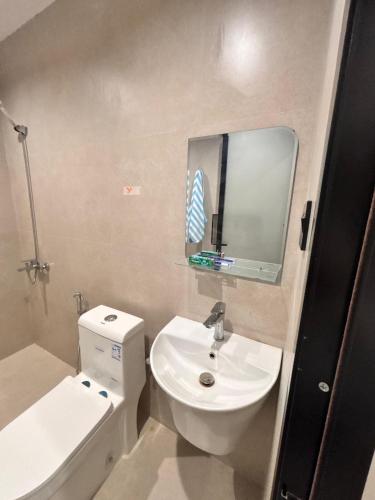 a bathroom with a white toilet and a sink at شقق حديثة موثثة in Dammam