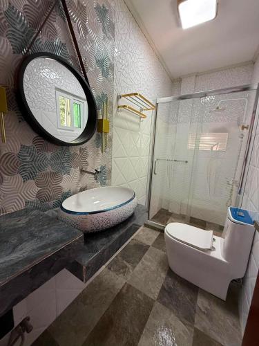 a bathroom with a sink and a toilet and a mirror at S&L Lodging House and Tampisaw Restaurant in Pandan