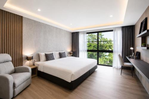 a bedroom with a bed and a couch and a window at Reiz - Private Residence in Chiang Mai