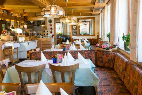 un ristorante con tavoli e sedie con tovaglioli sopra di Hotel Gasthof Rose a Oy-Mittelberg