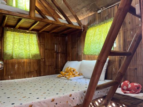 a bedroom with a bunk bed with a ladder at PAPABO Adventure Village in Moalboal