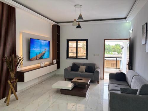 a living room with a couch and a tv at Luxury résidence Bassam in Moosou