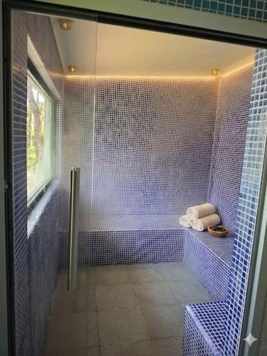 a blue tiled bathroom with a shower and a tub at Villa Colares in Sintra