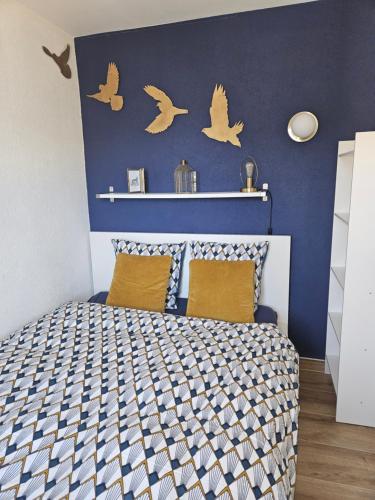 a bedroom with a bed with birds on the wall at Studio Cime de l'Est in Vérossaz