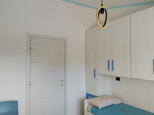 a bedroom with a door and a bed and a cabinet at L' Aurora Marina in SantʼAnna Arresi